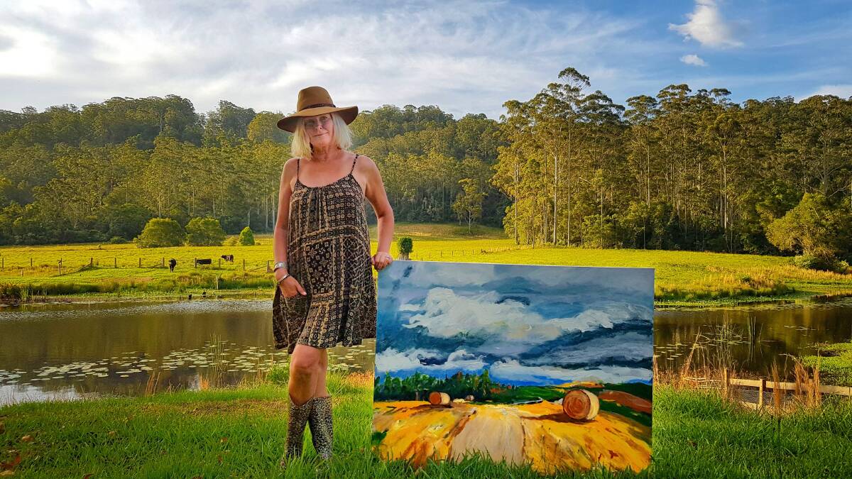 Beth Byrne with one of her acrylic landscape paintings.