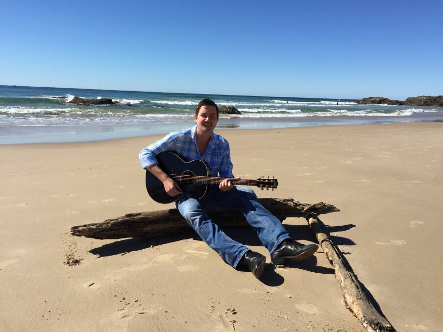 In paradise: Adam Harvey strums a tune on Town Beach, during a whirlwind trip to talk about his concerts with fellow country music star Beccy Cole. Photo: Vickii Byram