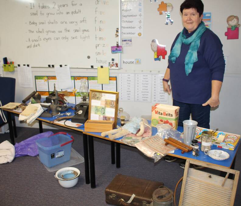 Remembering: Tinonee Historical Society president Jenny Cherry with the collection of artefacts taken to Taree Christian College for our talk recently. 