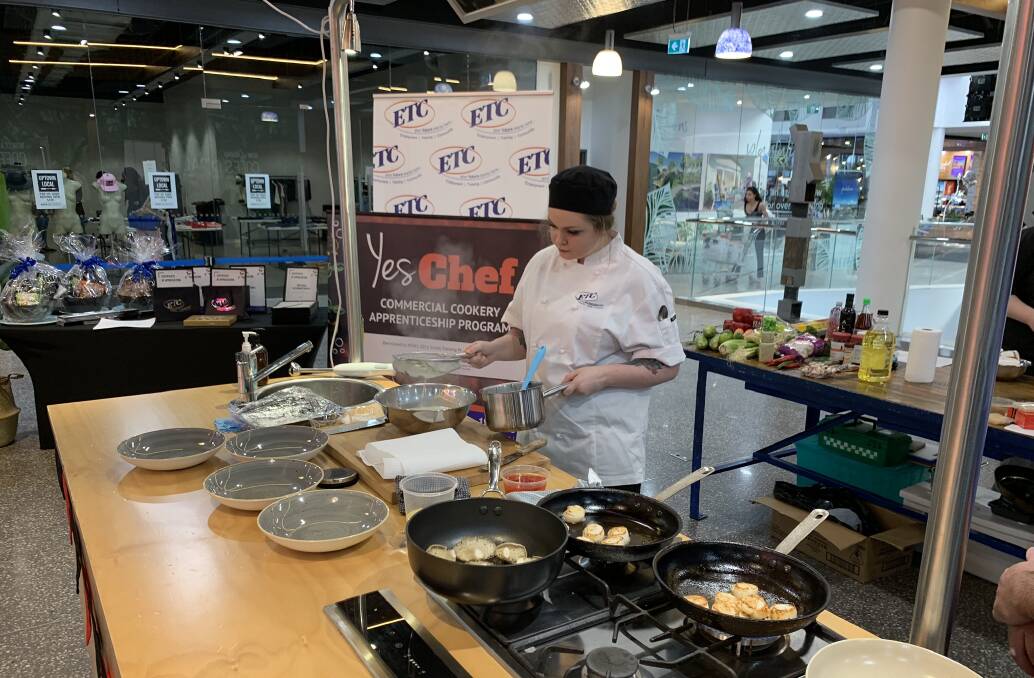 Club Taree apprentice chef Sarah Townsend cooking her grand final dish in Coffs Central Shopping Centre.