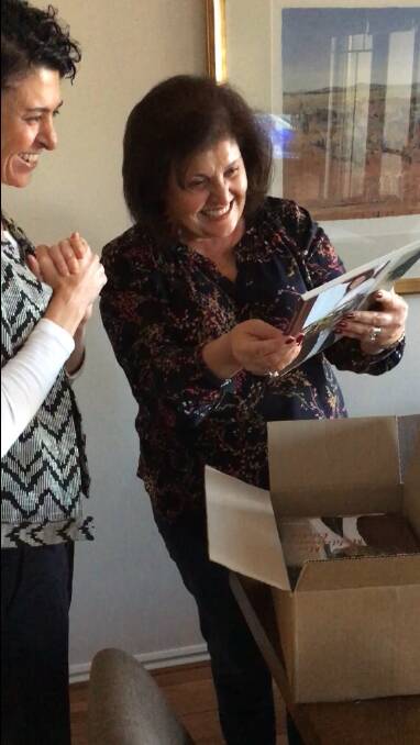 Pure joy: Mon Saad celebrates seeing a copy of her first cookbook, Mon's Mediterranean Kitchen, with her daughter Tanya Saad. Watch the video to share the milestone moment.