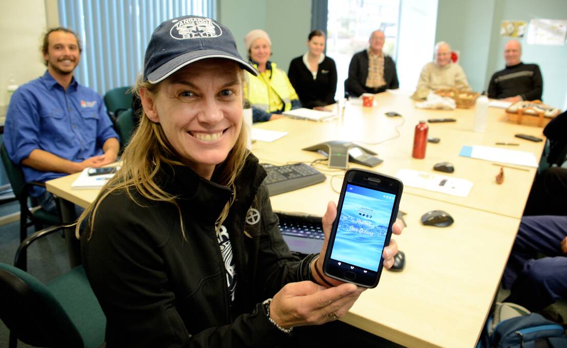 Tangaroa Blue managing director Heidi Taylor holds her phone displaying the new Australian Marine Debris Initiative app. She recently visited the region to rally community groups, organisations and individuals to use it including (from left) Rye Gollan, Kyrsten Banks, Erin Masters, John Elcoate, Bill Dennis and Chris Sheed.