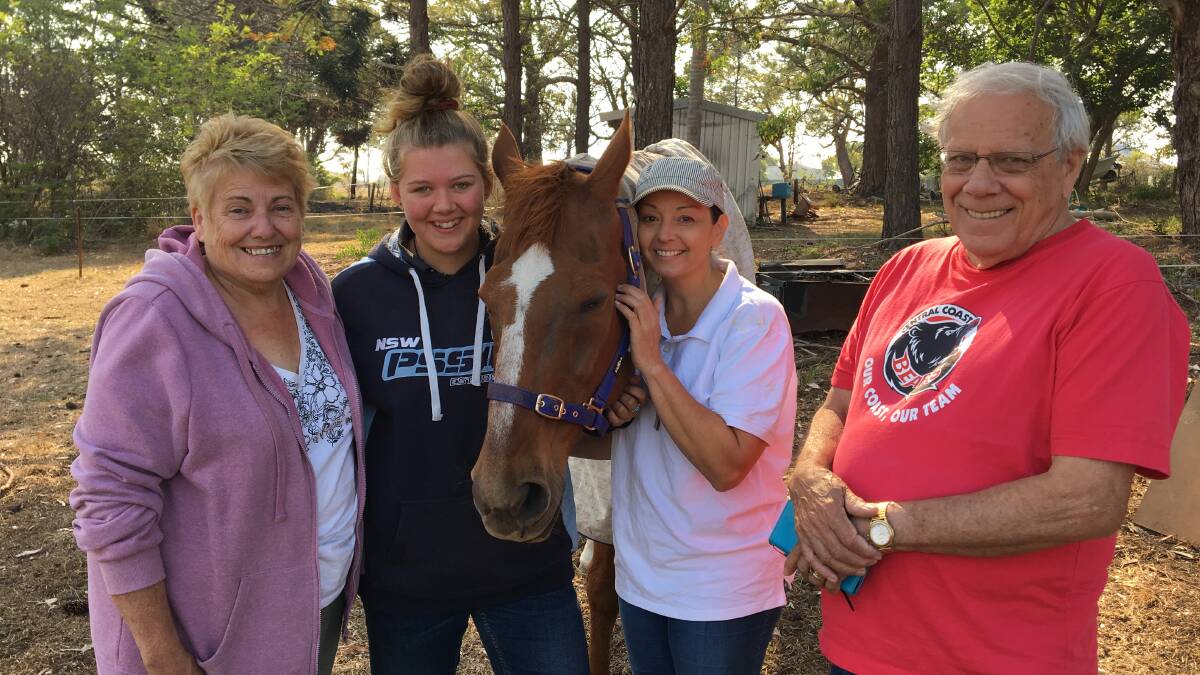 Sense Of Relief: Old Bar horse-owners Carole Isaacs, Natalia Hoawerth, Anamaree Correia and Bill Robertson with Red the horse, happy to be back on the Old Bar Road property where they keep their horses.