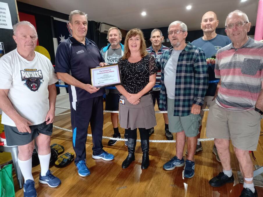 Boxing coach Dean Groth receives his Parkinson's Community Hero honour from members of the Port Macquarie support group.