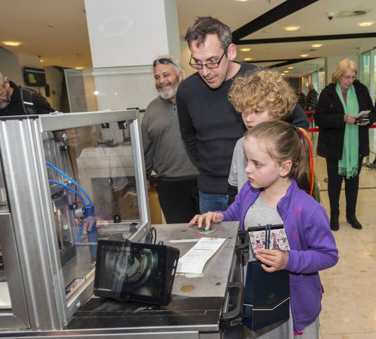 Fun process: Visitors strike their own coin with an "Australia" counterstamp at the Royal Australian Mint's Rascals & Ratbags Roadshow. Photo: Andrew Finch