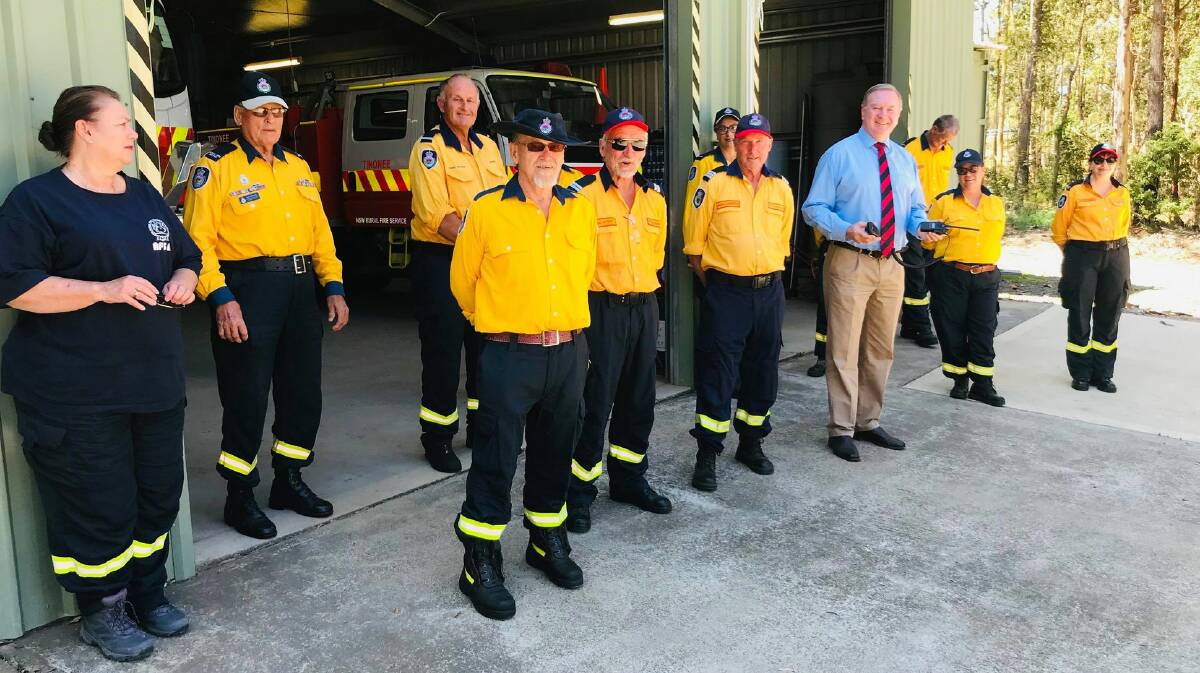 Members of Tinonee Rural Fire Brigade at their depot, with Member for Myall Lakes Stephen Bromhead inspecting one of the brigade's new radios. Photo: supplied