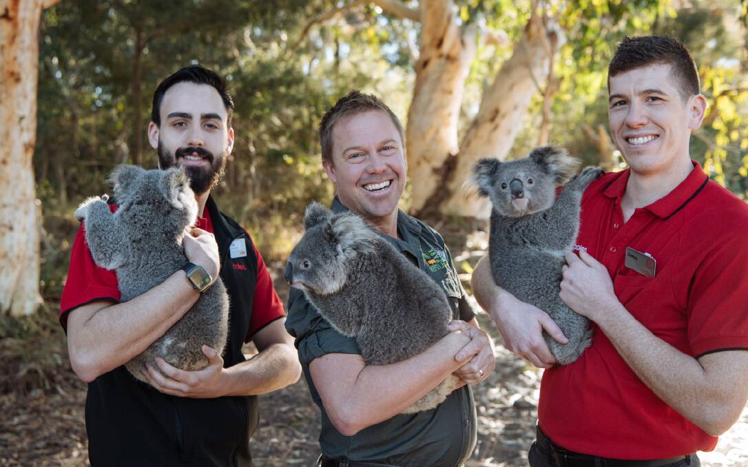 Aussie Ark president, Tim Faulkner (centre) with Coles employees, with one of the species set to benefit from the partnership. Photo: Aussie Ark
