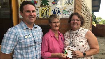 Susan Johnston and relieving principal Michael Lord of Woodburn Public School accepting the gift of books and puppets from Marj Phillips of Taree Quota Club. Photo supplied
