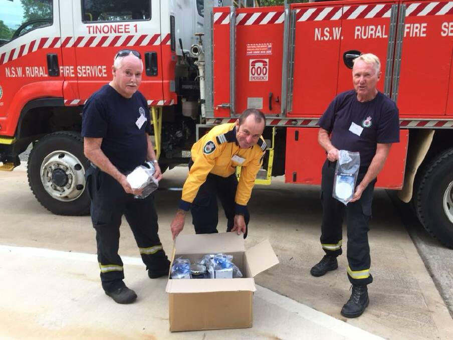 Roger Scott, captain Russell Coe and Bruce Annetts of Tinonee Fire Brigade taking delivery of the donated masks. Photo supplied