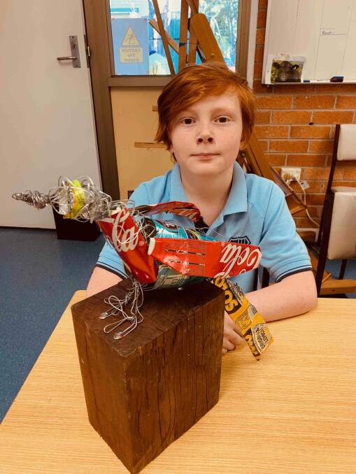 Chace Fletcher from Krambach Public School with his sculpture "We 'can' keep the bushland clean". Photo supplied