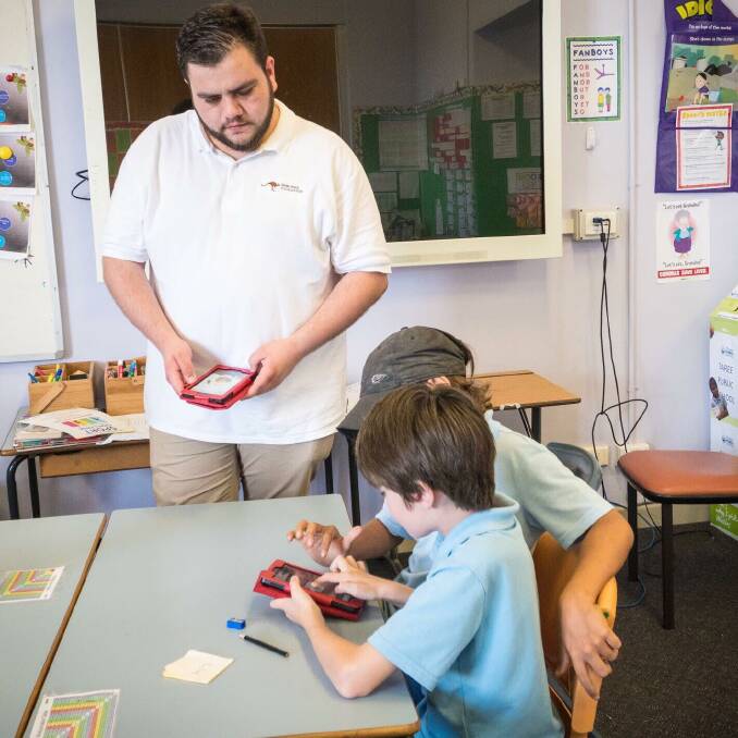 Bawurra Foundation co-founder Jesse Stok with Taree Public School students in 2017,when he gifted them with Kindles loaded with a library of local Inidigenous information and stories. Photo: submitted