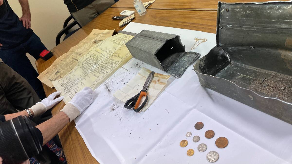 The time capsule (right), its outer casing (centre) and the contents laid out. Picture by Julia Driscoll.