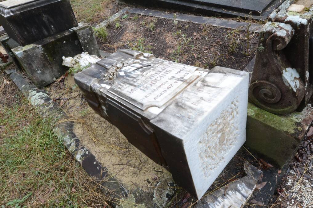 A historic headstone taken off its mount and laid down by MidCoast Council. Sand was later packed underneath it to prevent further damage. Photo: Scott Calvin