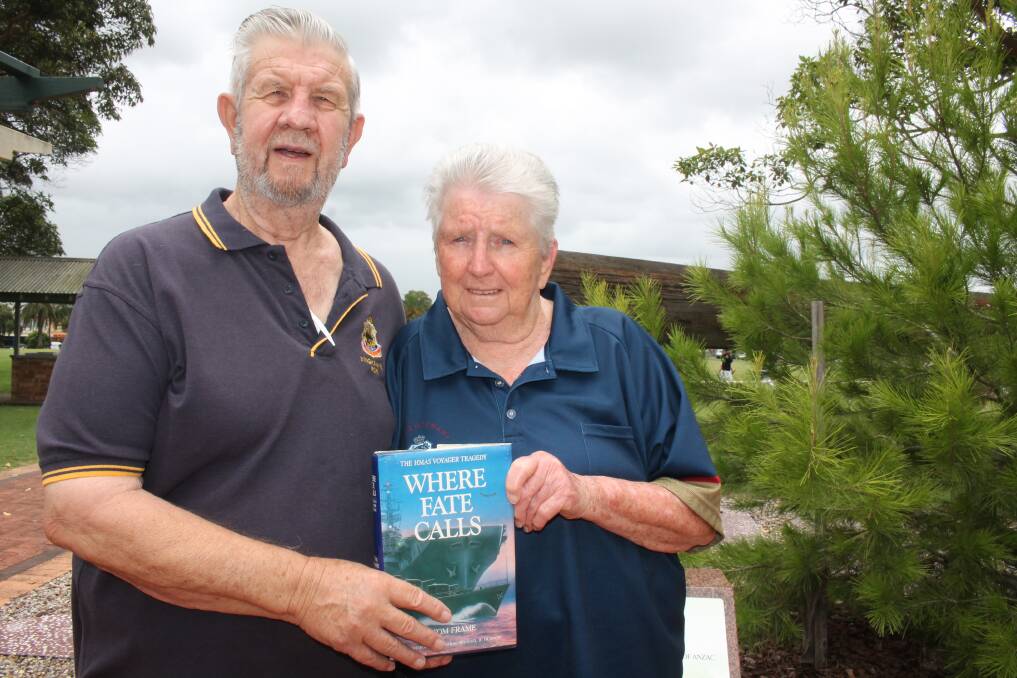 Ron and Lesley Irwin at Wingham's Central Park, with a book about the HMAS Voyager tragedy. Photo: Pam Muxlow