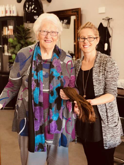 Taree Quota Club member Jeanette Holland and The Barbers Chair hairdresser Jessica, with the hair donated by a local young girl. Photo: supplied
