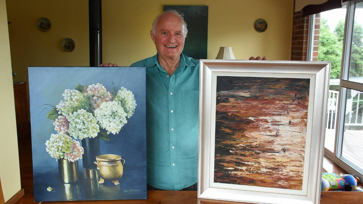 Raffle prizes: Terry Stanton with the paintings created and donated by Tinonee artists Helen and Ron Hindmarsh. Photo: Scott Calvin
