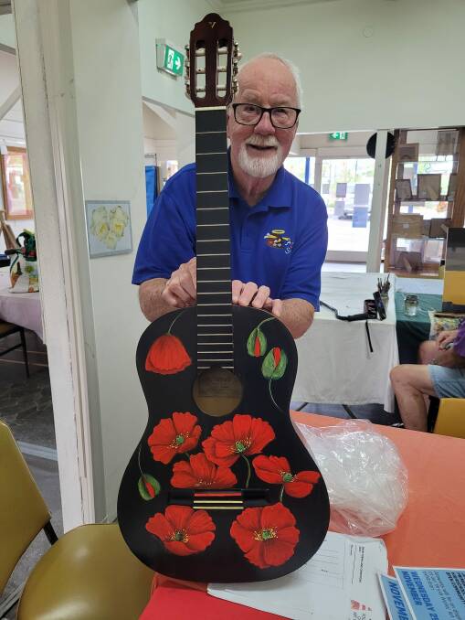 Co-founder of Art and Soul, Ron Hindmarsh, with a guitar painted for Guitars for Vets. Picture supplied. 