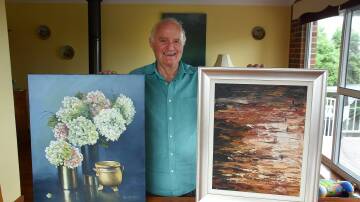 Bed Inn Bus founder Terry Stanton, with the two paintings donated by Ron and Helen Hindmarsh for raffle prizes. Photo: Scott Calvin