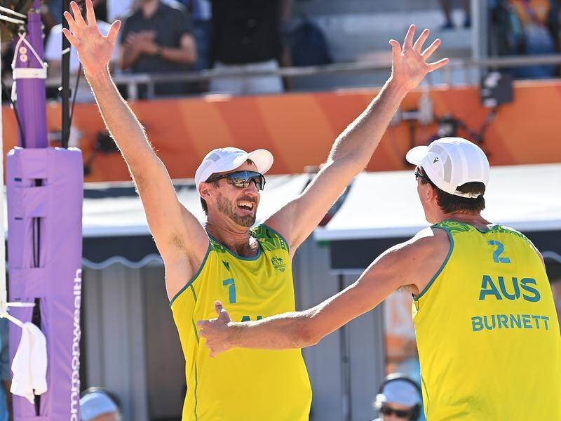 Australia's Chris McHugh (l) and Paul Burnett celebrate winning men's beach volleyball gold. (Andrew Cornaga/AAP PHOTOS)