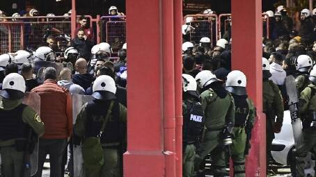 Greek riot police detain fans near an Athens volleyball arena after a policeman was fatally injured. (AP PHOTO)