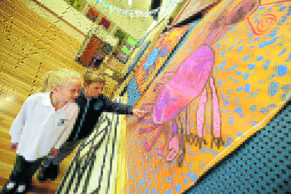 Kindergarten students Sara Harris and Oliver Haines examine one of the collaborative artworks.