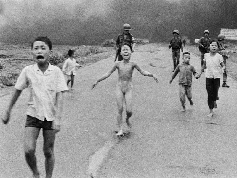 A nine-year-old Kim Phuc (C) was photographed fleeing after being hit with napalm in the Vietnam War