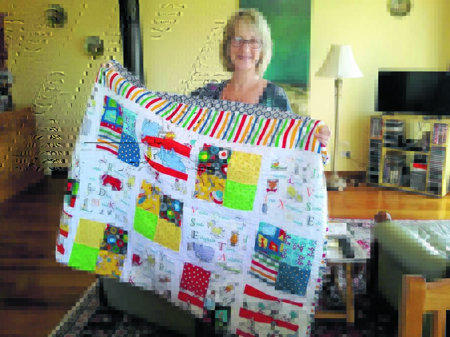 Christine Stanton with the Dr Seuss inspired quilt, made by Dusty Walkom, which she won in a Rotary fundraiser.