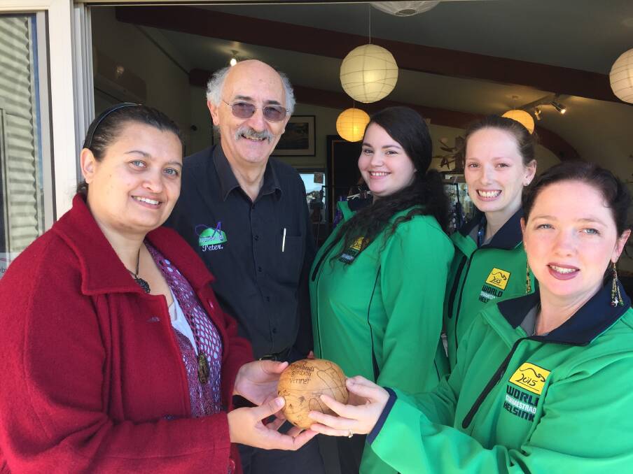 Artists Yeena Robins and Peter Calabria from Artisans on the Hill present Gymaroo team members Simariah Cusbert and Rebecca Boyd and coach Sarah Hayes with a wooden bowl decorated with hands of friendship sharing across the ocean which will be left as a gift in Denmark.