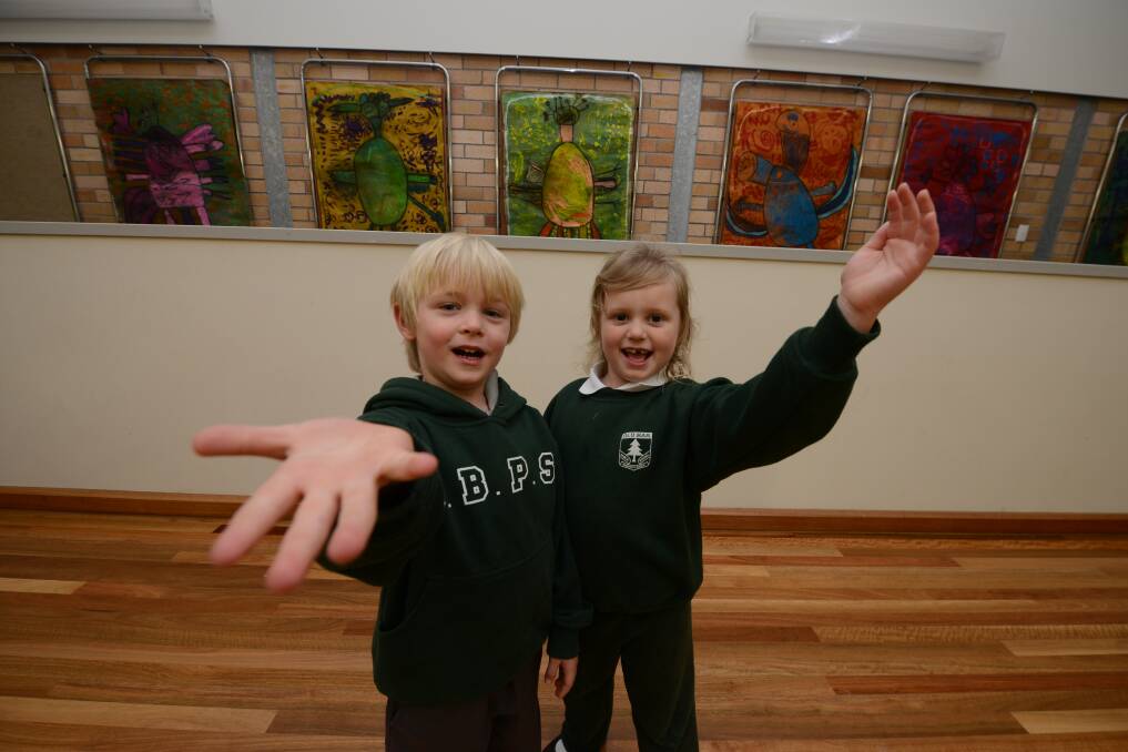 Ta da!: Carter Doessel and Amelia Maddy with some of the collaborative artworks created by the kindergarten classes.