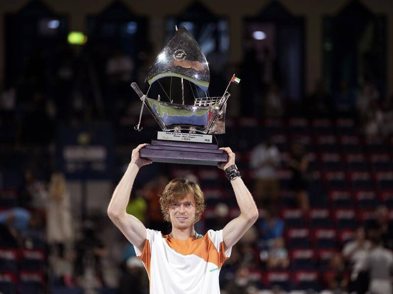 Andrey Rublev lifts his Dubai Tennis Championships trophy, his third title in the space of a week.