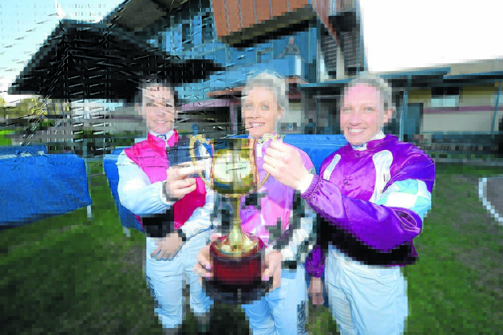Jockeys Belinda Hodder, Melinda Graham and Alison Threadwell with the XXXX Gold Taree Cup, the prize for the winner of Sunday s 2000 metre race.