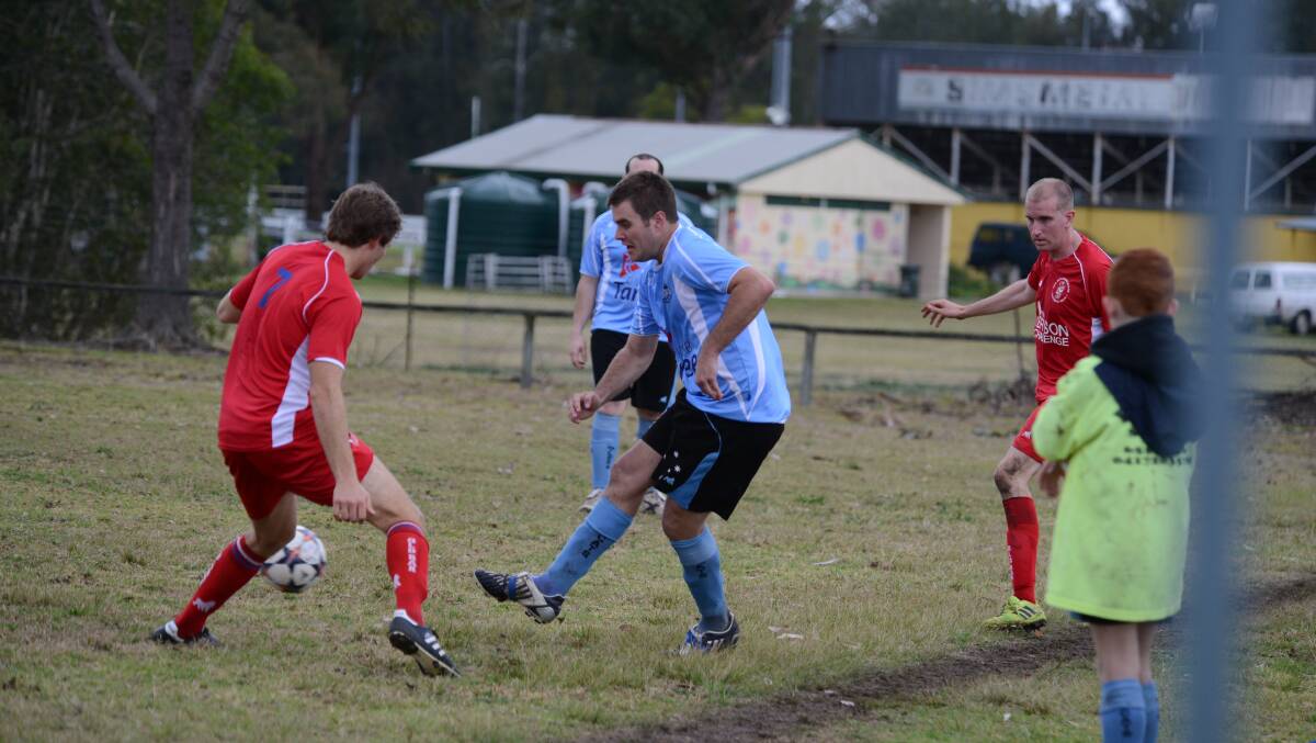 Taree's Josh Bithrey tries to get the ball past an Old Bar defender during the Football Mid North Coast Premier League clash at Omaru Park. The game ended in a 1-1 draw. 