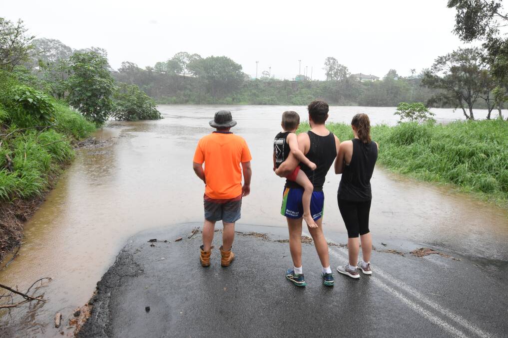 No access: Residents observe the Bight Bridge completely submerged in flood water. Photo: Scott Calvin.
