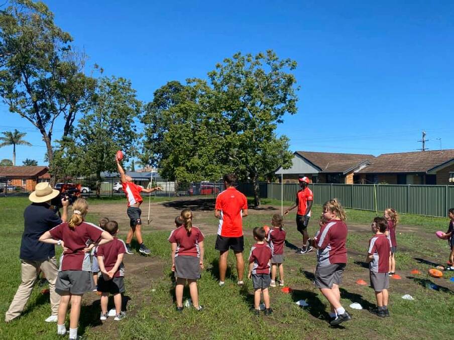 Learning new skills: Sydney Swans players showed Taree West Public School students about the fundamentals of Australian Rules football. Photo: AFL North Coast.