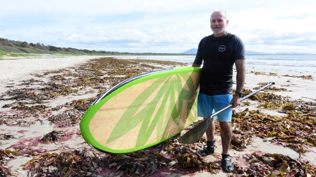 Paddle boarder Ross Moylan has never seen so much red seaweed at Crowdy Head Beach in his life. Photo: Scott Calvin.