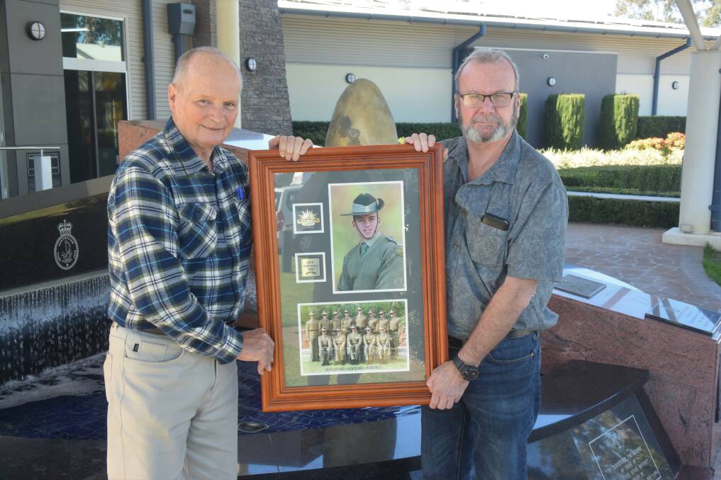 Taree RSL Sub-branch's Darcy Elbourne and John Connell with the photo of Anthony Whittaker. 