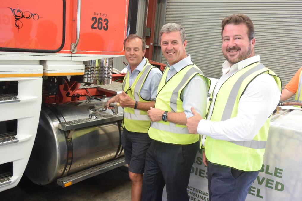 Jim Pearson fuels a truck with Member for Lyne Dr David Gillespie and IGE Solutions chairman Paul Dickson.