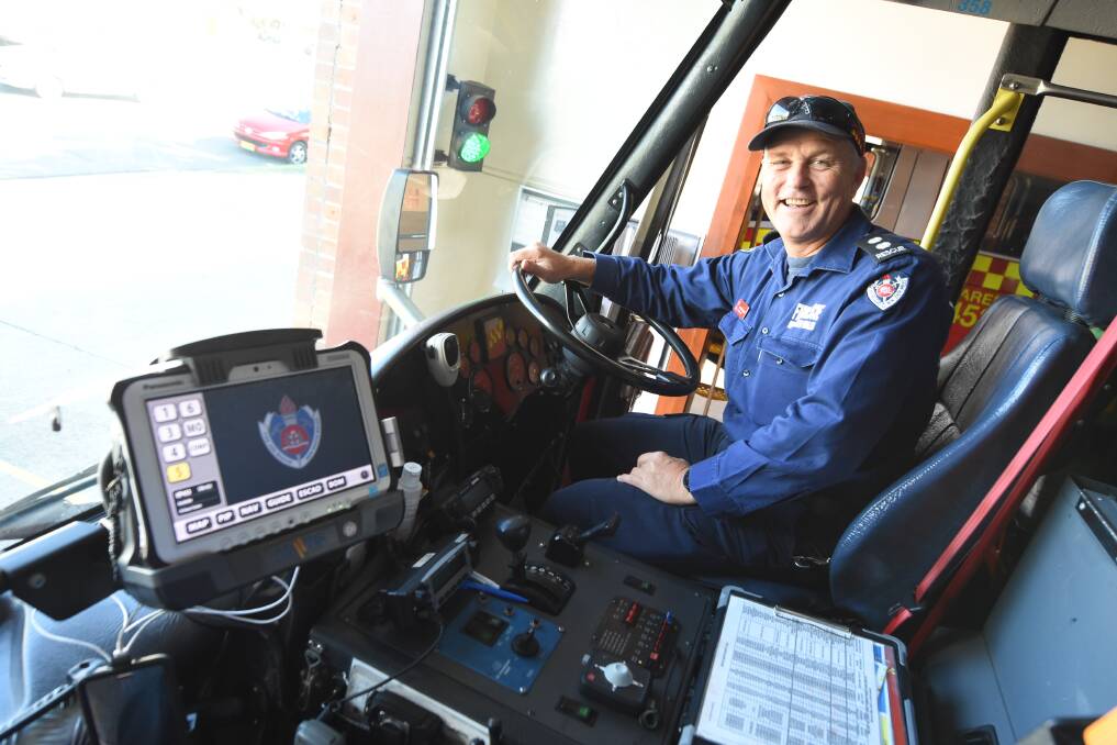 Climb aboard: Taree Fire Station Commander Peter Willard ready to head out on another job with the truck. Photo: Scott Calvin.