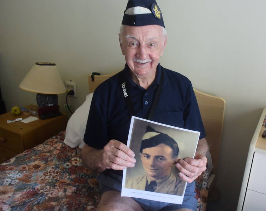 Remembering: Clive Matheson holds a photo of himself that was taken after he enlisted in the Royal Australian Air Force over 70 years ago. Photo: Rob Douglas.  