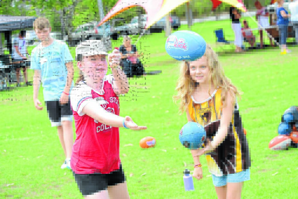 Emily Croker and Sienna Thornton practice their handball technique during the AFL come and try day.